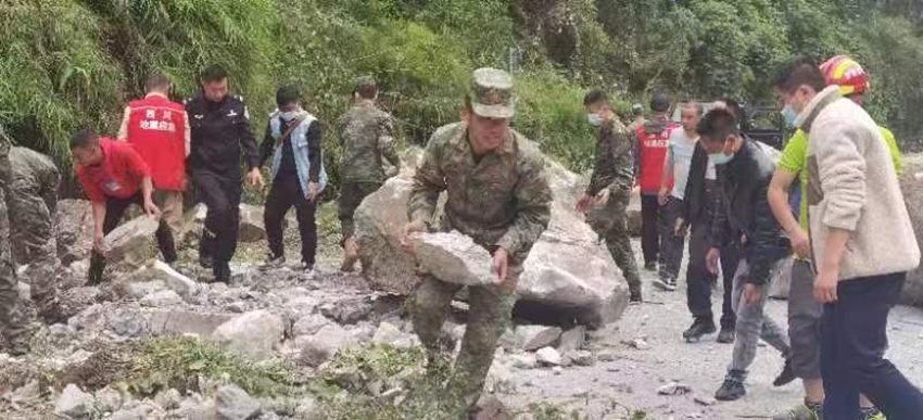搬開落石清理道路。四川省軍區供圖