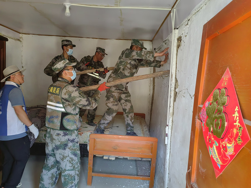 楊愛理（右一）在排除房屋安全隱患。陸軍第77集團(tuán)軍某旅供圖