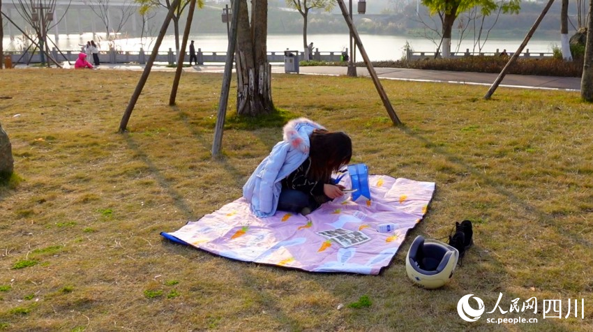 市民在花萼濕地公園草坪曬太陽(yáng)。鐘欣航攝