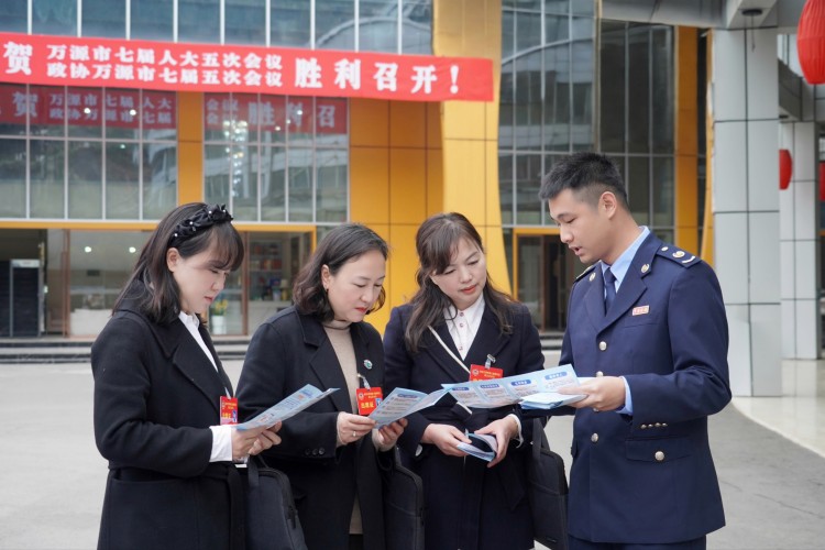 稅務干部向萬源“兩會”代表宣傳稅費政策。萬源市稅務局供圖