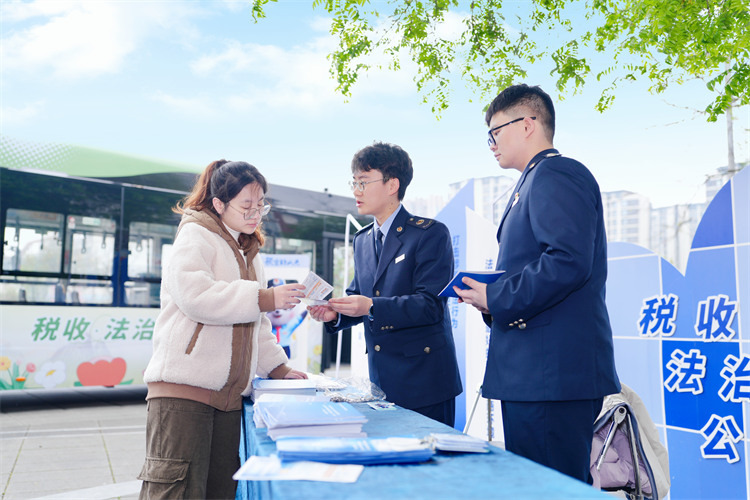 稅務(wù)干部在公交車站為納稅人講解稅收政策。成都市稅務(wù)局供圖