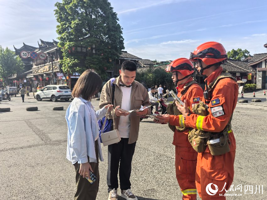 5月1日，都江堰景區(qū)，消防員唐平、譚弋飛正在進行防火宣傳。程雪力攝