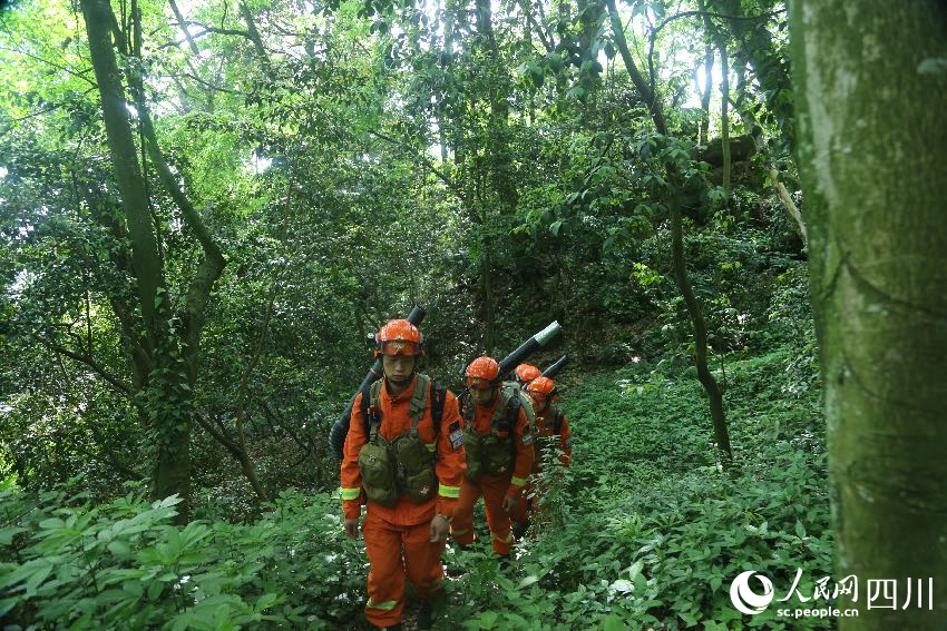 5月1日，林區深處，消防員們正在巡護火情火點。程雪力攝