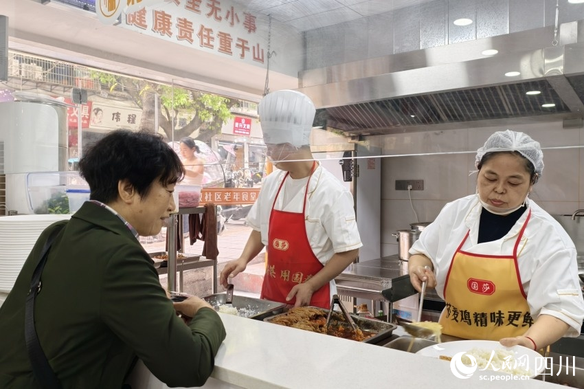 老年食堂取餐口前，廚師正在按需為老人打飯。人民網 趙祖樂攝