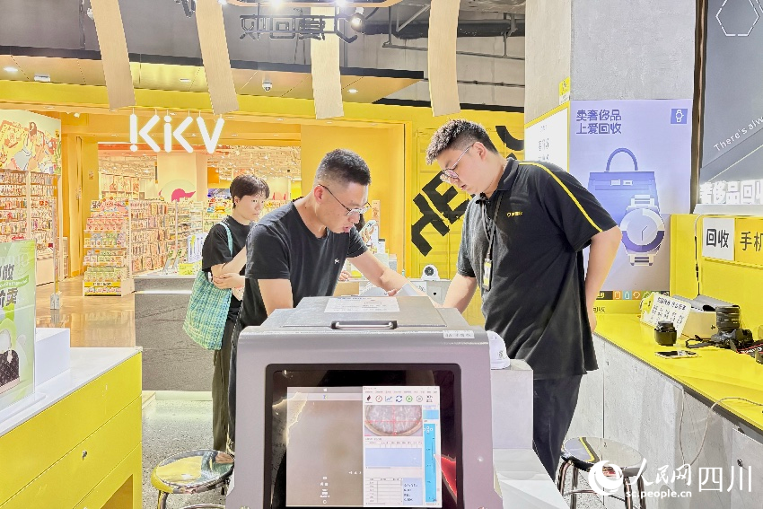 市民在回收點工作人員的幫助下，完成交易。人民網記者 朱虹攝
