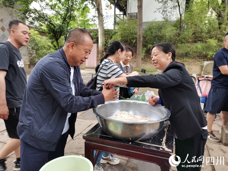工作人員正在指導(dǎo)游客包粽子。李建生攝