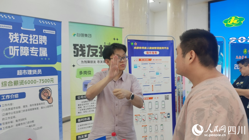 自強(qiáng)集團(tuán)招聘專員用手語(yǔ)與應(yīng)聘殘友溝通。施瑩攝