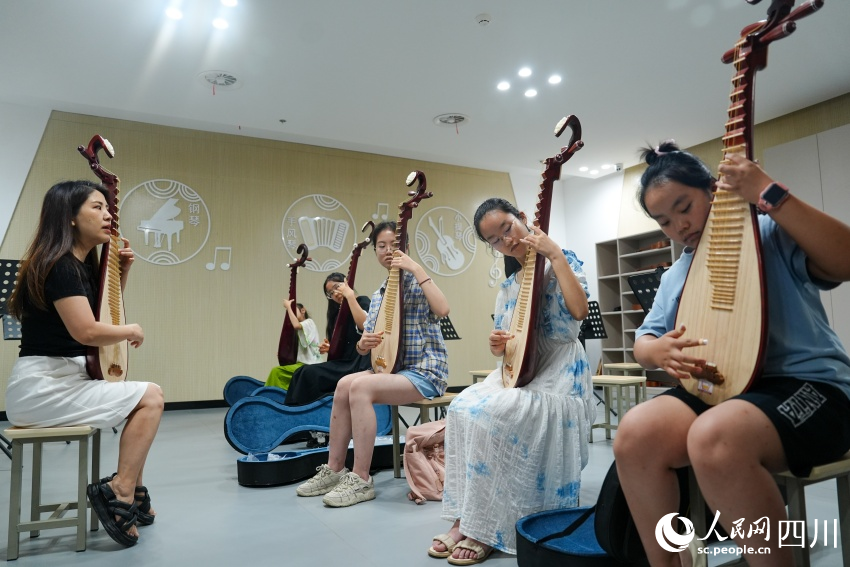孩子們在眉山市彭山區文化館“藝啟武陽文化課堂”暑期公益培訓班上學習琵琶彈奏。翁光建攝