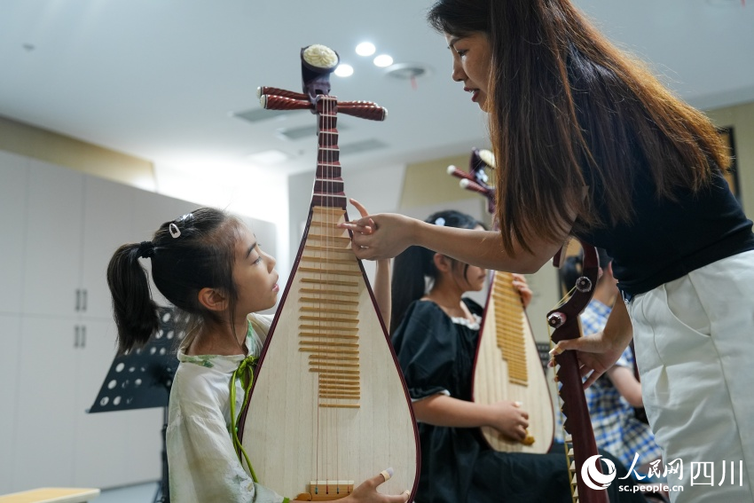 孩子們?cè)诿忌绞信砩絽^(qū)文化館“藝啟武陽(yáng)文化課堂”暑期公益培訓(xùn)班上學(xué)習(xí)琵琶彈奏。翁光建攝