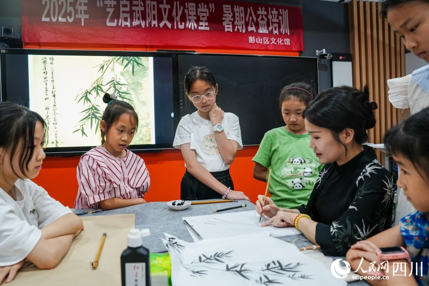 四川大學(xué)錦江學(xué)院“90后”副教授高子然在眉山市彭山區(qū)文化館為孩子們講解中國畫知識。人民網(wǎng) 趙祖樂攝