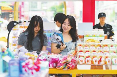 7月14日，游客在官方特許商品零售店紅星路店挑選世運會周邊商品。
