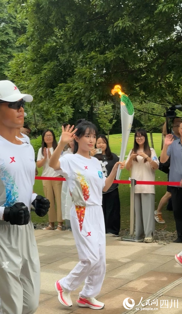 李子柒一邊傳遞一邊向場邊揮手。成都世運會執委會供圖