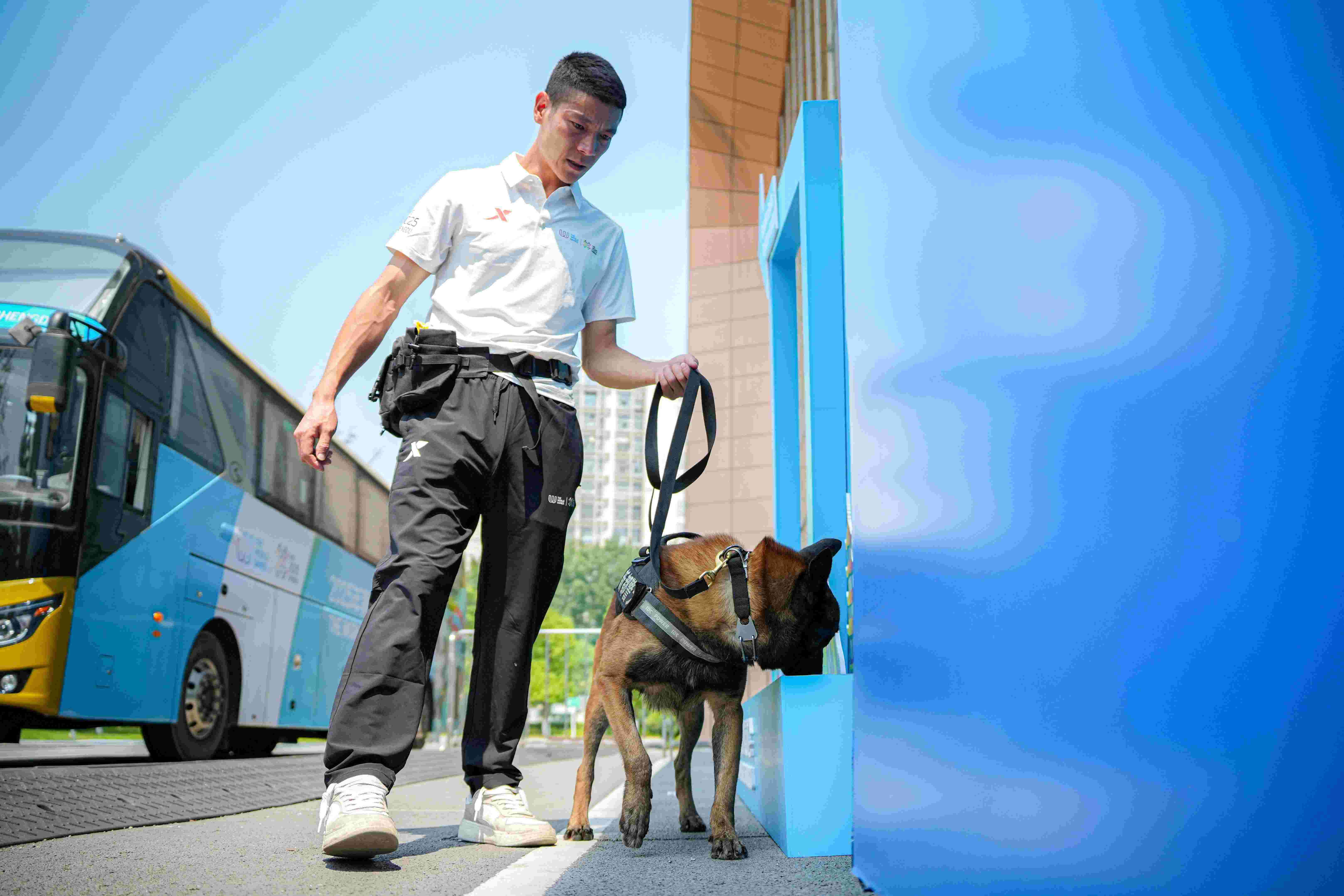 訓犬員韓學軍與搜爆犬黑龍對場館外進行安檢。新都公安供圖