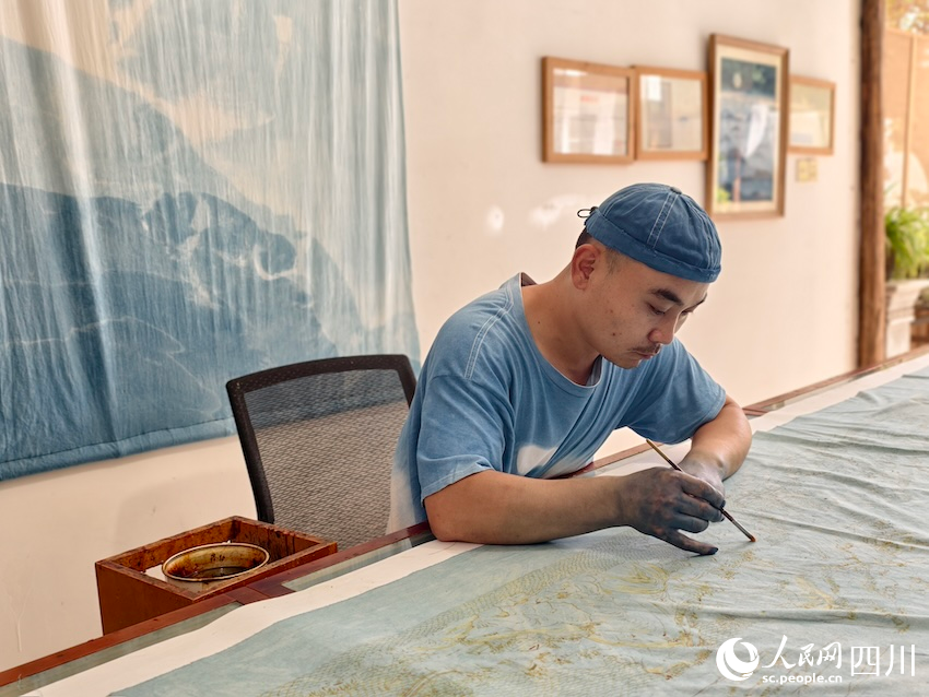 謝寶高正在進(jìn)行蠟染藝術(shù)創(chuàng)作。人民網(wǎng)記者 郭瑩攝
