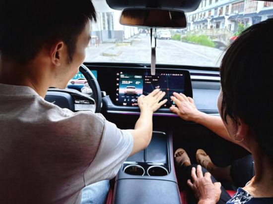 阿豪向村里的老人演示新能源汽車的智能體驗。受訪者供圖